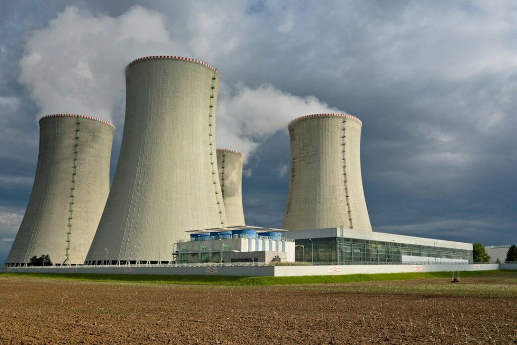Concrete cooling towers of a nuclear power plant emitting steam under a cloudy sky
